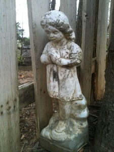Guardian Angel statue Statue of a little girl clasping her hands and looking down, next to a white picket fence